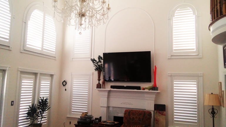 Phoenix great room with wall-mounted television and high-ceiling windows.